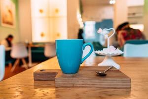 Hot cappuccino coffee in coffee shop on wooden table photo