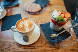 Cappuccino with spoon in cup and dessert photo
