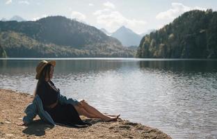 The girl in the dress and hat of the lake in the mountains photo