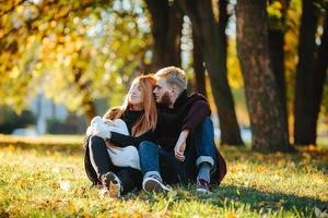 familia joven e hijo recién nacido en el parque de otoño foto