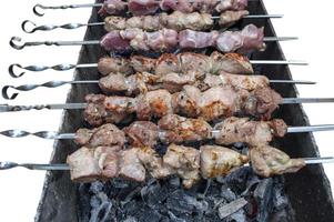 fresh pieces of meat are fried on skewers photo