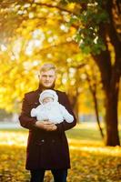 papá e hijo recién nacido en el parque de otoño foto