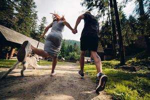 couple runs on road in the nature with dog photo