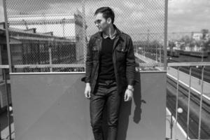 A man dressed in jeans on the background of the train and the station photo