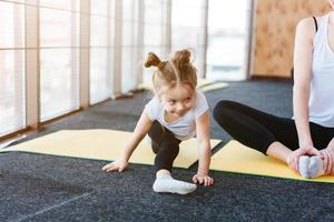 A little girl repeats exercises for her mother photo