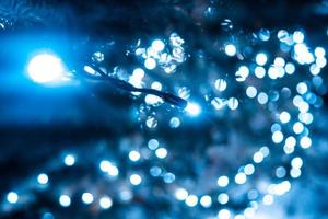 Christmas tree with cones on a city street illuminated with a garland. photo