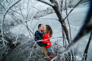 beautiful couple posing near a frozen river photo