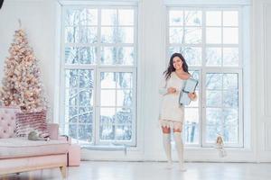 Beautiful young girl in white dress posing on camera. Christmas concept photo