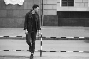 A man dressed in jeans on the background of the old city photo