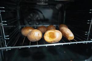 Baked potatoes in their skins in the oven photo