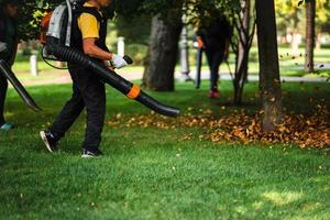 A woman operating a heavy duty leaf blower. photo