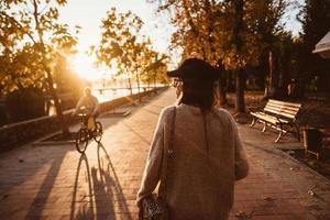 atractiva, joven morena con el pelo largo caminando por el parque de otoño. foto