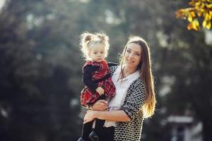 Mother and little daughter playing in a park photo