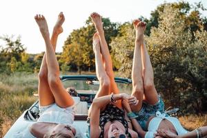 Three girls are lying on the trunk photo