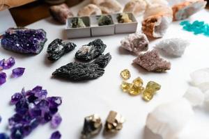 Collection of beautiful precious stones on white table. photo