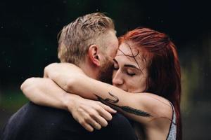 beautiful couple hugging in the rain photo