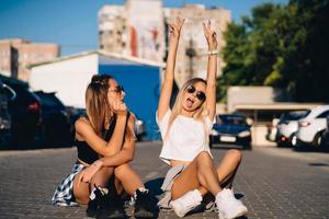 Two young, sexy girls are sitting on the ground photo