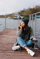 Young pretty girl on wooden bench on old pier photo