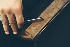 strong man sharpens old razor photo