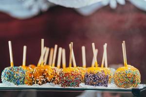 Apples in caramel and sprinkles. Street food. photo