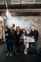 dos familias jóvenes posando contra una pared gris foto