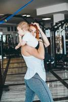 joven madre con su hijo pequeño en el gimnasio foto