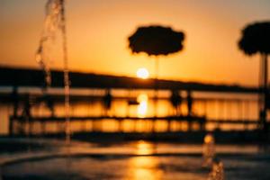 stream of a fountain splashes water, sunset photo