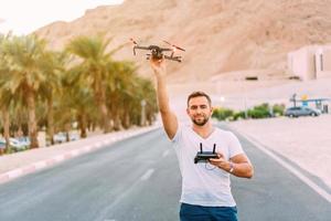 Young man holding drone before flight at nature photo