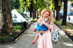 Woman hugs her daughter, holding her in her arms photo