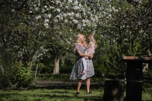 madre torcer hija en el jardín foto