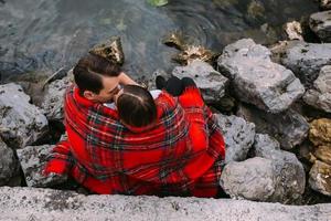 Young beautiful couple sitting on the beach photo