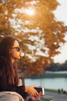 Attractive woman using smartphone outdoors in the park photo