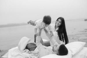 Happy young family relaxing together on the lake photo