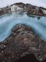 Beautiful quarry, the lake is covered with ice photo