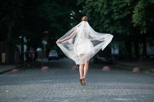 Bride jumps with vail photo