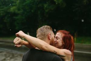 beautiful couple kissing  in the rain photo