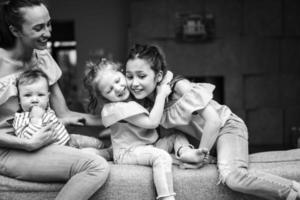 Mom, two daughters and a little son on the couch photo