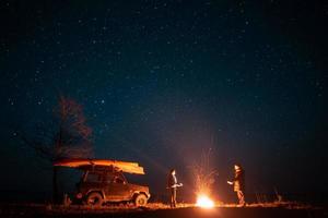 feliz pareja hombre y mujer de pie frente a la hoguera ardiente foto