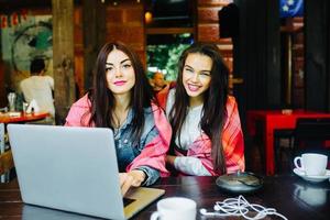 two girls watching something in laptop photo