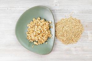 top view of whole oat grains and boiled porridge photo