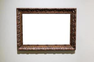carved wide dark brown picture frame on gray wall photo