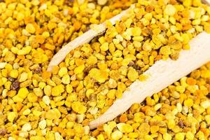 portion of natural bee pollen in wooden scoop photo