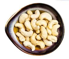 top view of cashew seeds in ceramic bowl isolated photo