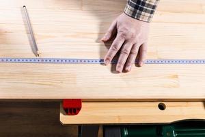 top view of measuring tape on new wooden board photo