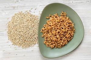 top view of whole rye grains and boiled porridge photo