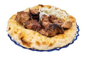 grilled kebab on flatbread on plate isolated photo