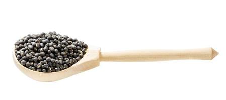 whole black urad beans in wooden spoon isolated photo