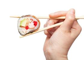 chopsticks hold western-style sushi roll close up photo