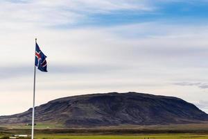 bandera islandesa y vista de la colina en islandia foto