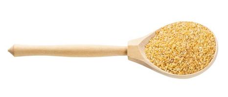 spoon with crushed polished wheat grains isolated photo